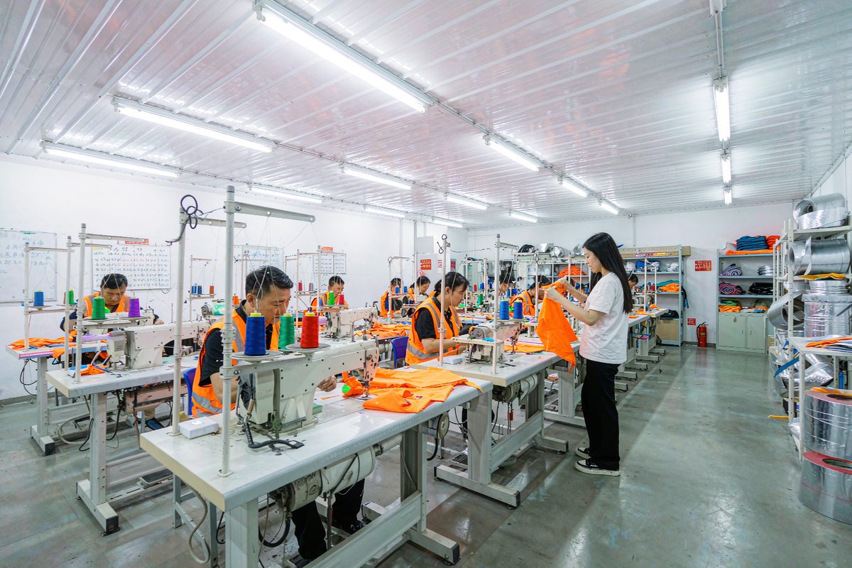 Sunwardwear garment factory floor with workers sewing high-visibility safety clothing