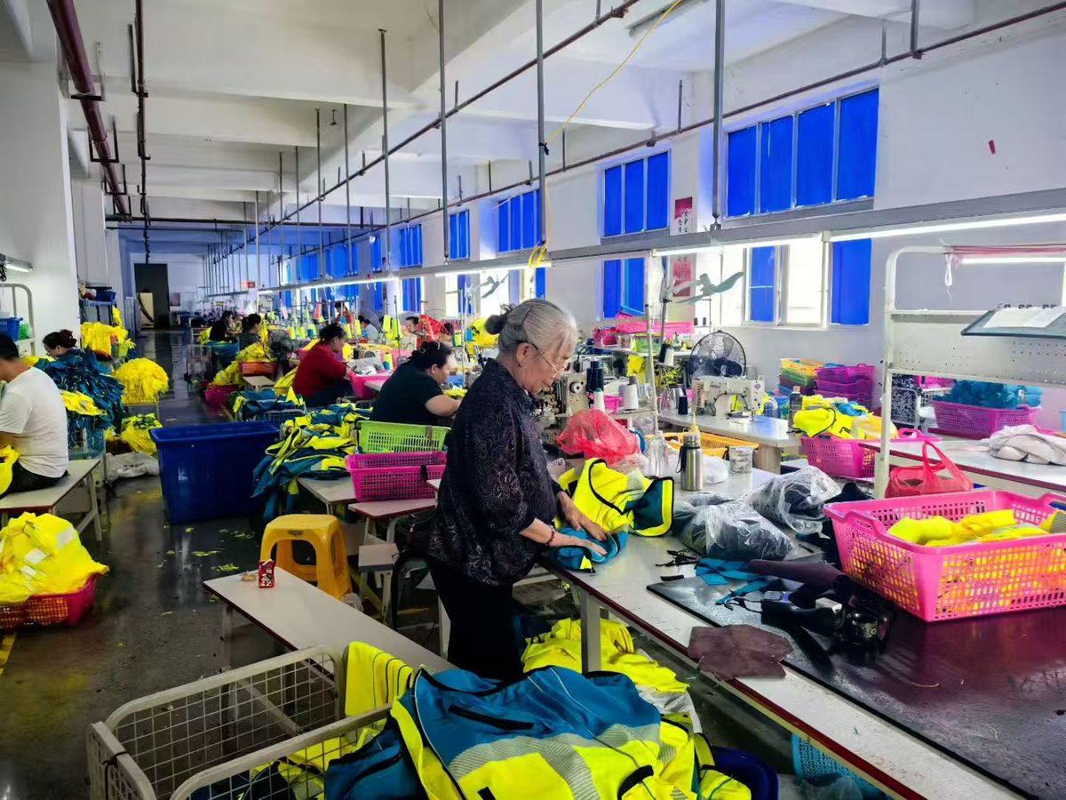 Workers sewing hi-vis reflective garments at Sunwardwear production tables